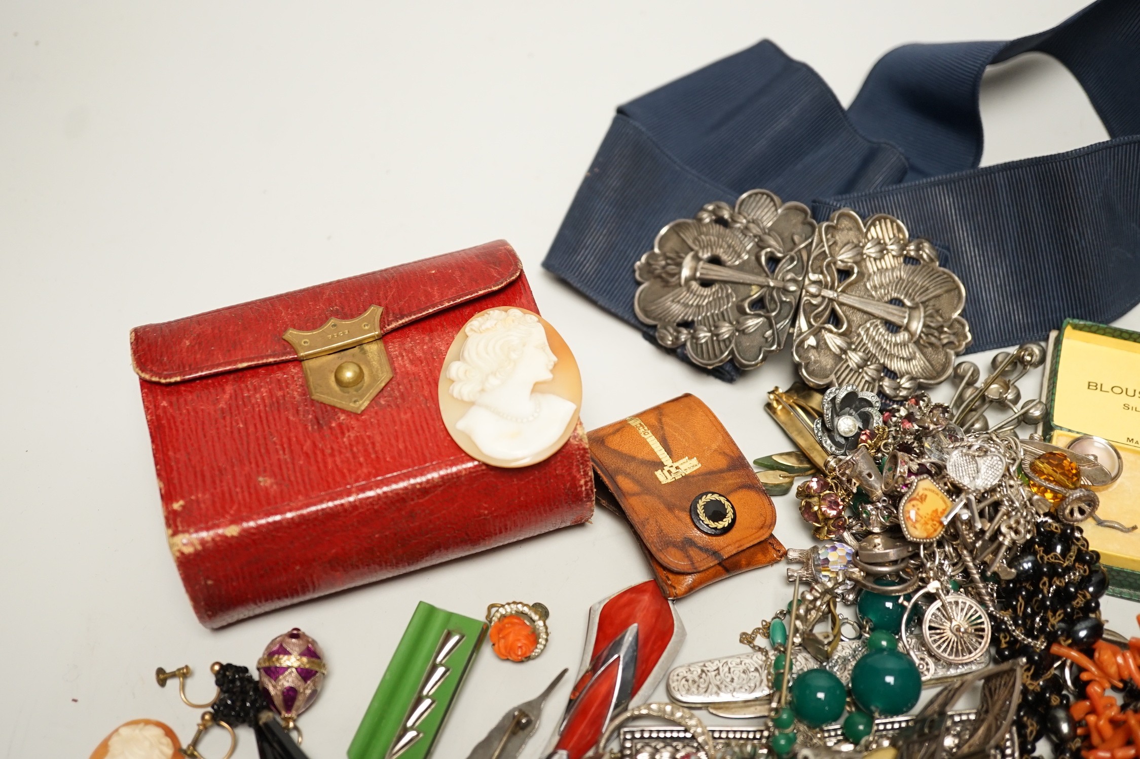 Assorted costume jewellery and other items including a silver belt buckle and enamelled egg pendant.